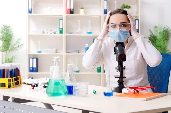 Laboratuvarda çalışan genç bir kadın kimyager. — Stok fotoğraf