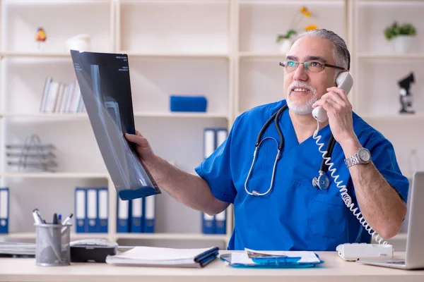 Beyaz sakallı yaşlı doktor radyolog klinikte çalışan — Stok fotoğraf