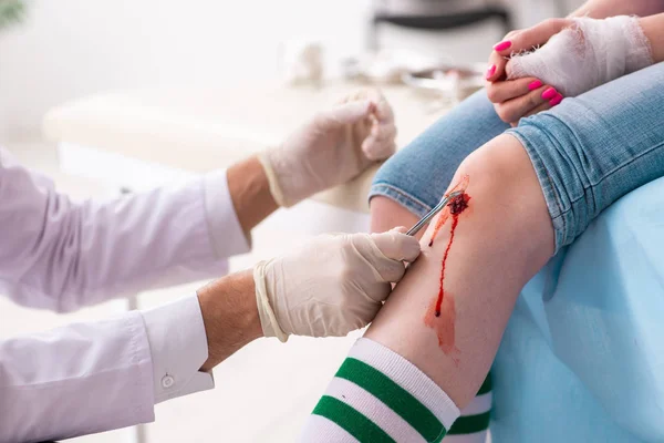 Pierna lesionada joven mujer visitando médico masculino —  Fotos de Stock