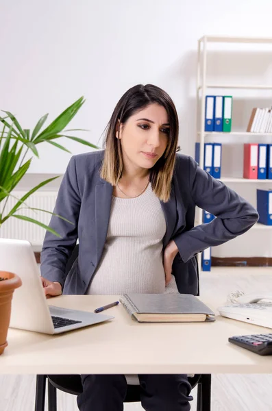 Νεαρή έγκυος υπάλληλος που εργάζεται στο γραφείο — Φωτογραφία Αρχείου