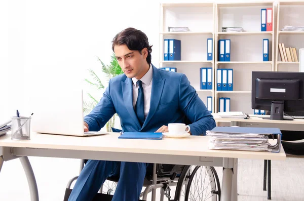 Empregado masculino em cadeira de rodas trabalhando no escritório — Fotografia de Stock