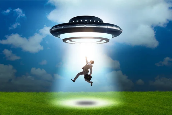 Flying saucer abducting young businessman — Stock Photo, Image