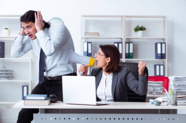 Yaşlı kadın patron ve genç erkek çalışan ofiste.  