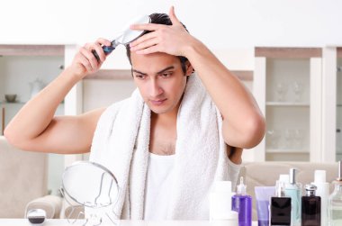 Genç yakışıklı adam banyoda. 