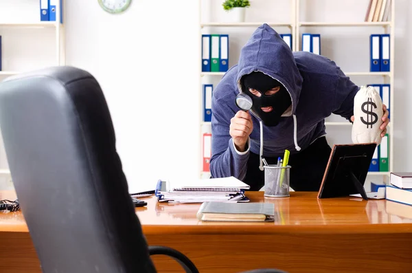 Männlicher Dieb mit Sturmhaube im Büro — Stockfoto