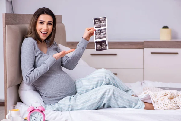 Mujer embarazada joven en el dormitorio — Foto de Stock