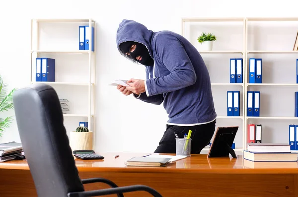 Männlicher Dieb mit Sturmhaube im Büro — Stockfoto