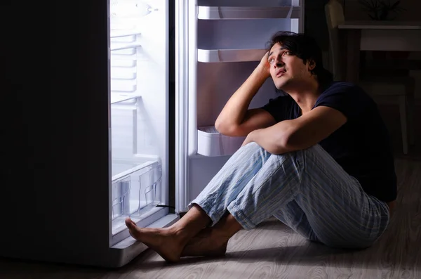 Man breaking diet at night near fridge — Stock Photo, Image