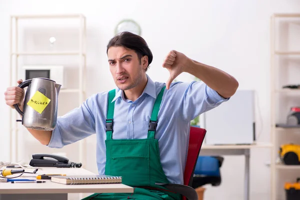 Young man repairing kettle in service centre — Stock Photo, Image