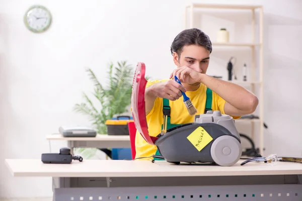 Man repairman repairing vacuum cleaner