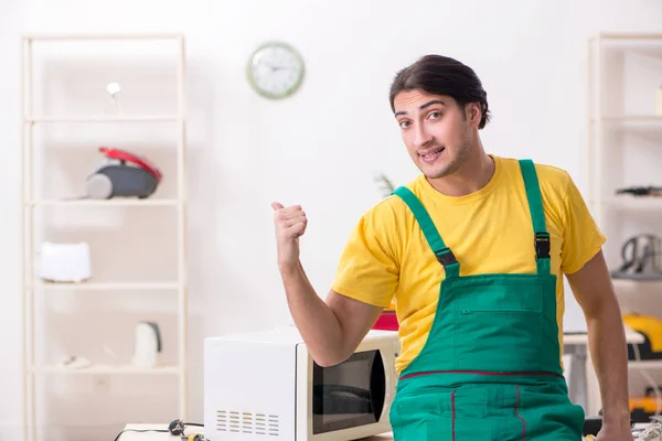 Joven técnico de reparación de microondas en el centro de servicio — Foto de Stock