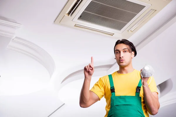 천장 냉방 장치를 수리하는 젊은 수리공 — 스톡 사진