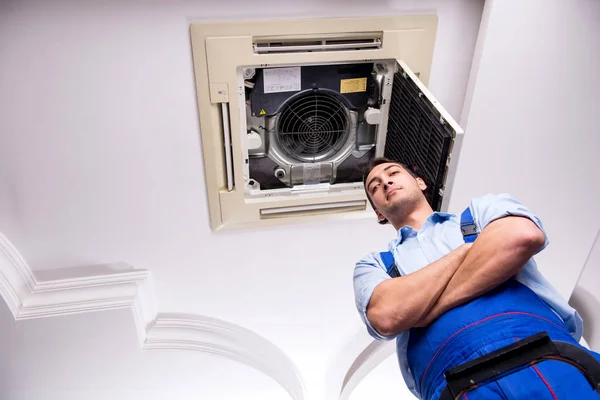 Joven reparador reparación de la unidad de aire acondicionado del techo —  Fotos de Stock