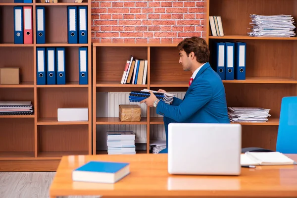 Jovem e bonito empregado sentado no escritório — Fotografia de Stock