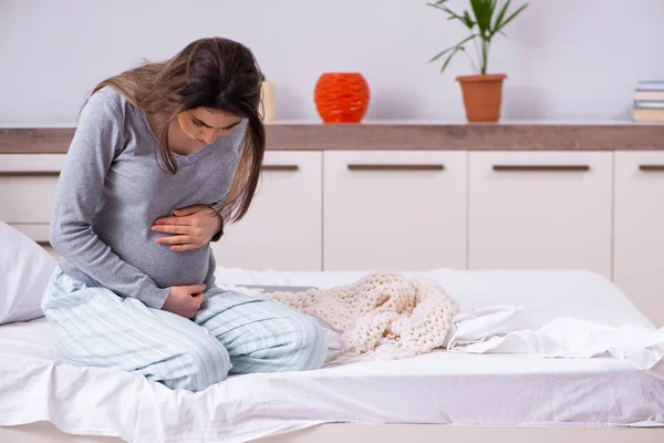 Jonge zwangere vrouw in de slaapkamer — Stockfoto