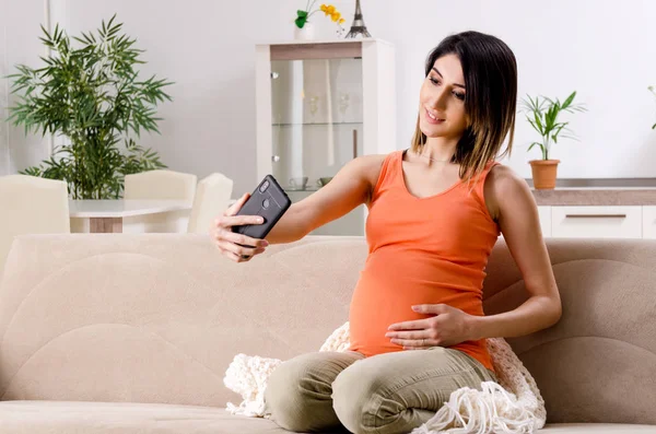 Giovane donna incinta a casa — Foto Stock