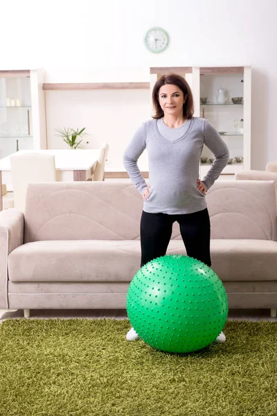 Mulher grávida envelhecida fazendo exercícios em casa — Fotografia de Stock