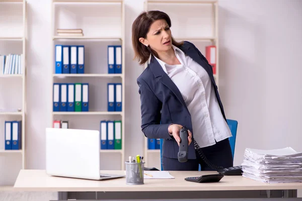 Middle-aged female employee suffering in the office
