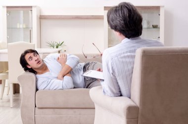 Genç erkek hasta psikologla kişisel sorunları tartışıyor.