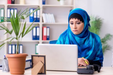 Ofiste çalışan tesettürlü kadın çalışan.