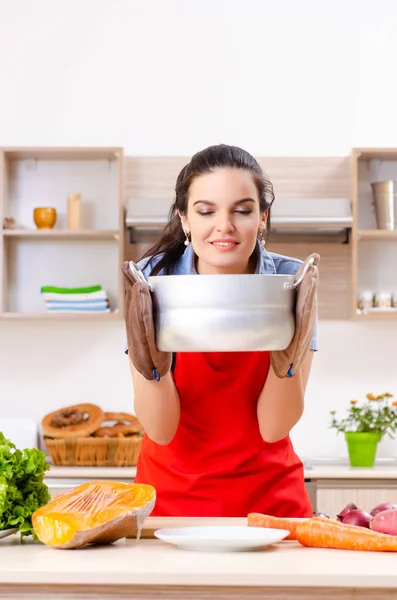 Jonge vrouw met groenten in de keuken — Stockfoto