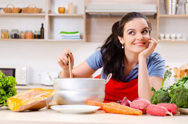 Mujer joven con verduras en la cocina — Foto de Stock