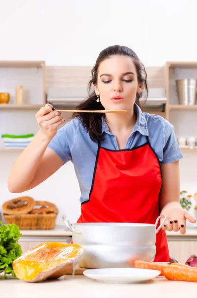 Jovem com legumes na cozinha — Fotografia de Stock