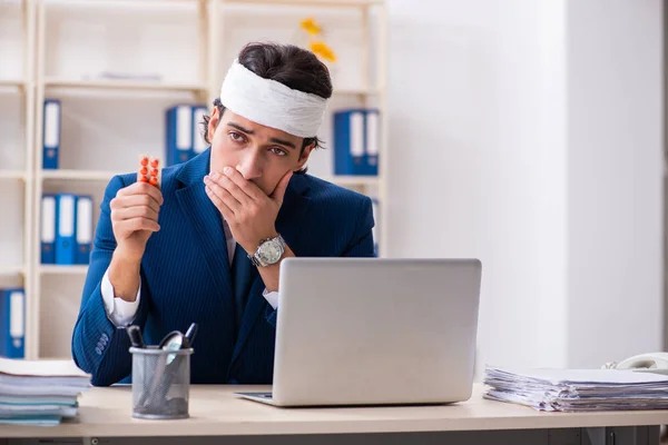 Head injured male employee working in the office