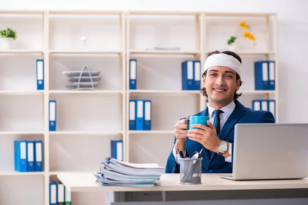 Head injured male employee working in the office