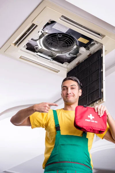 Young repairman repairing ceiling air conditioning unit — Stock Photo, Image