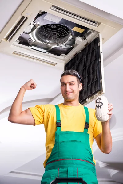 Young repairman repairing ceiling air conditioning unit — Stock Photo, Image