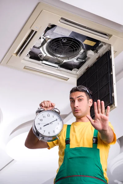 Mladý opravář opravuje stropní klimatizační jednotku — Stock fotografie