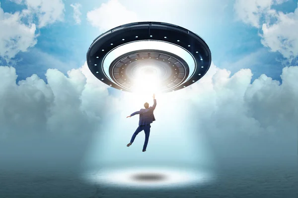 Flying saucer abducting young businessman — Stock Photo, Image