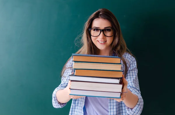 Female student in front of chalkboard — Stock Photo, Image