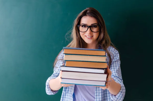 Estudante feminina na frente do quadro — Fotografia de Stock