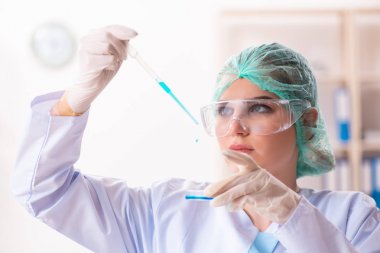 Laboratuvarda çalışan genç bir kadın kimyager. 