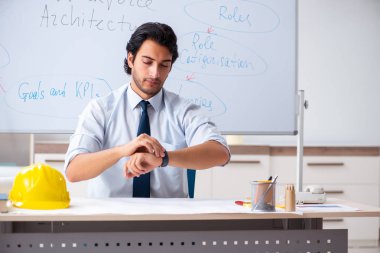 Genç erkek mimar beyaz tahtanın önünde. 