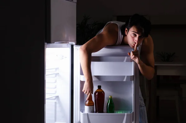 Man breaking diet at night near fridge — Stock Photo, Image