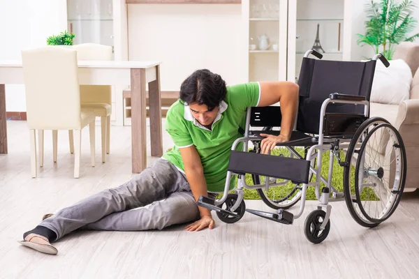 Jonge knappe man in rolstoel thuis — Stockfoto