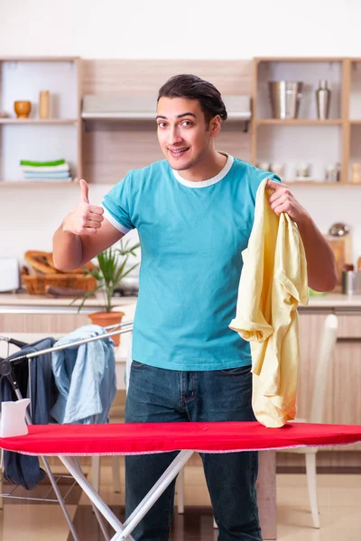 Młody mężczyzna mąż robi pranie ubrań w domu — Zdjęcie stockowe