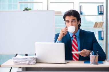 Genç yakışıklı iş adamı beyaz tahtanın önünde 