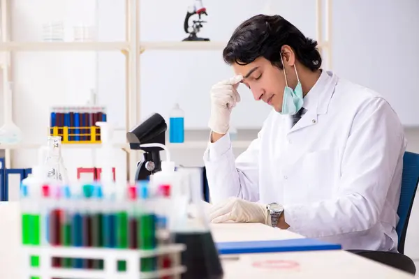 Jonge knappe chemicus die in het lab werkt — Stockfoto