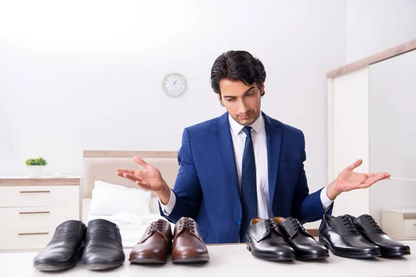 Jovem empresário bonito escolhendo sapatos em casa — Fotografia de Stock