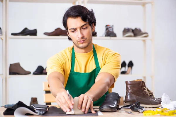 Jongeman herstellen van schoenen in werkplaats — Stockfoto