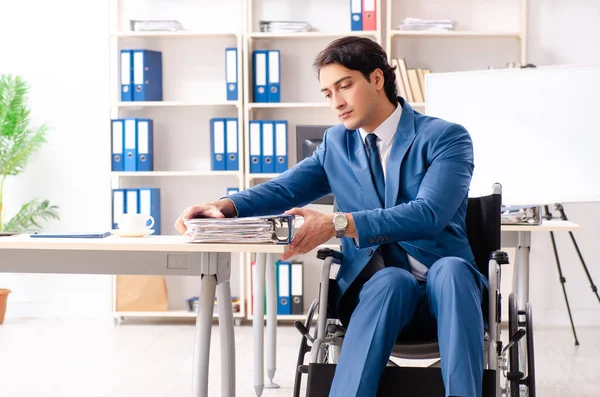 Männlicher Mitarbeiter im Rollstuhl im Büro — Stockfoto