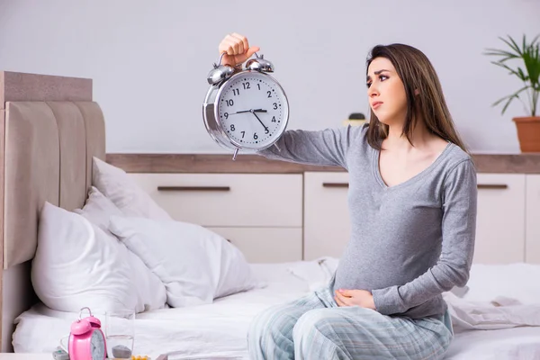 Молодая беременная женщина в спальне — стоковое фото