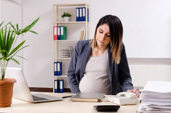 Jonge zwangere werkneemster op kantoor — Stockfoto