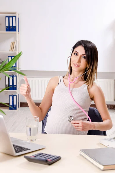 Jeune employée enceinte travaillant au bureau — Photo