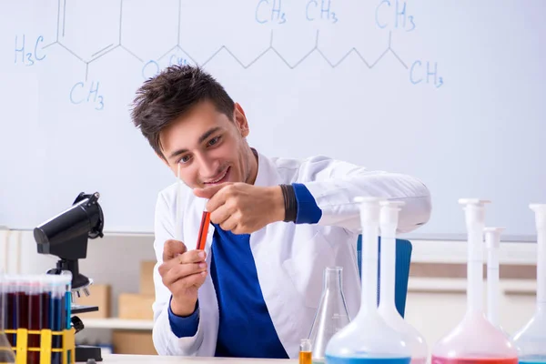 Junge Chemikerin sitzt im Labor — Stockfoto