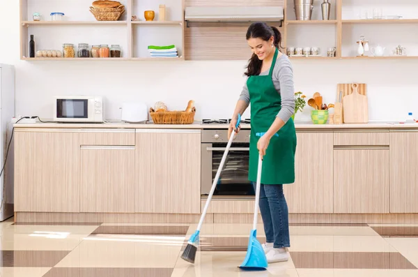 Jovem empreiteira fazendo tarefas domésticas — Fotografia de Stock